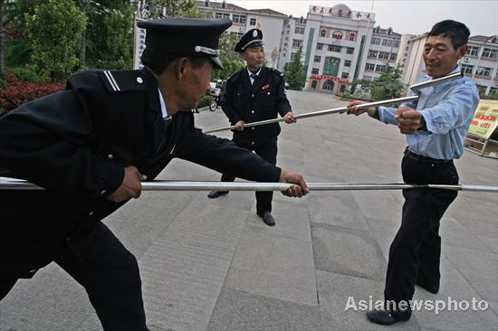 Security guards contain an attacker with specially designed forks in a mocked attack in Dongming Middle School in Weifang, East China's Shandong province May 2, 2010. Security guards contain an attacker with specially designed forks in a mocked attack in Dongming Middle School in Weifang, East China's Shandong province May 2, 2010.