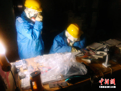 Two staff workers from the Tokyo Electric Power Company check equipment and collect data in the control room of the Fukushima Daiichi nuclear power plant on March 23, 2011. Two staff workers from the Tokyo Electric Power Company check equipment and collect data in the control room of the Fukushima Daiichi nuclear power plant on March 23, 2011.
